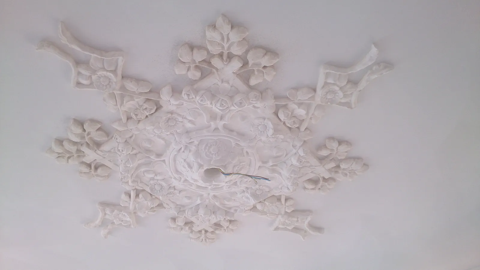 Gerestaureerd plafondornament in wit stucwerk